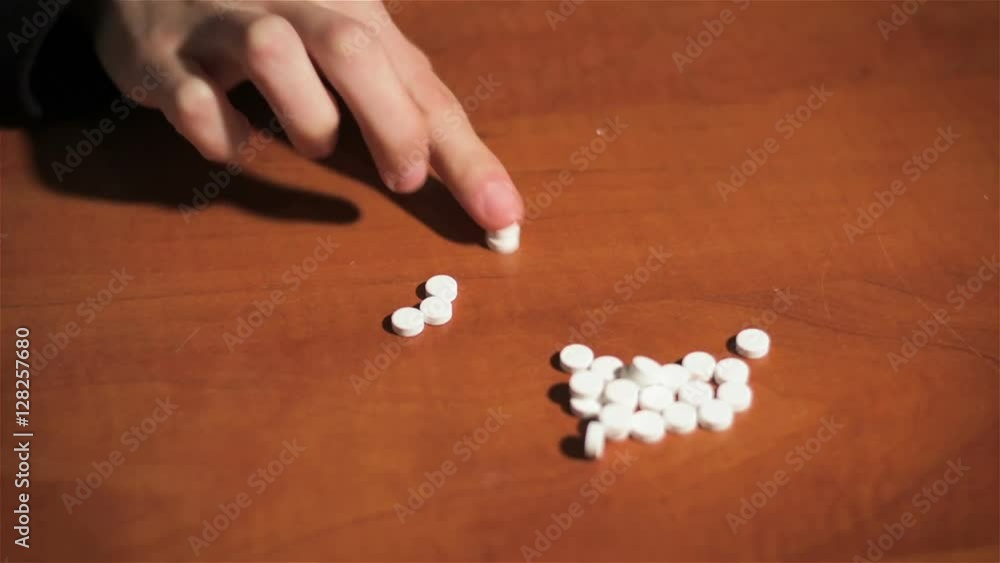 Young woman writes word SOS using pills. People take pills. Pills and drugs close up Young woman writes word SOS using pills. People take pills. Pills and drugs close up
