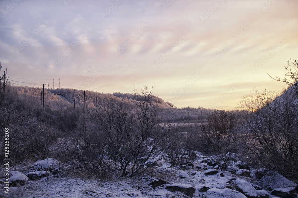 Snow-covered hills and the forest at sunset Snow-covered hills and the forest at sunset