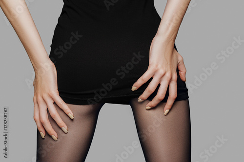 Bilde på lerret Closeup picture of female back in short black dress with hands o