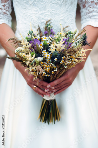 bouquet dried flowers in hands of bride