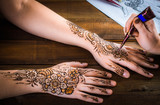 woman mehendi artist painting henna on the hand