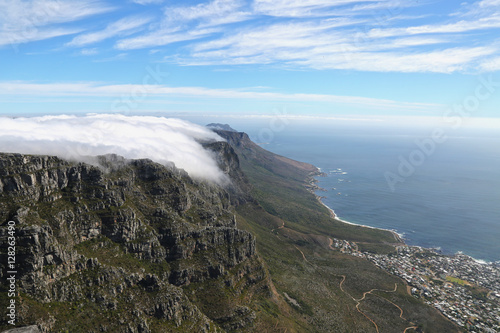 table mountain in south africa with clouds on the top and capetown on the foot of the mountain