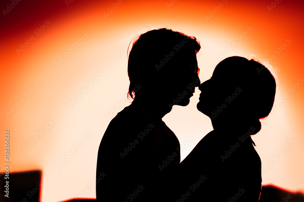 silhouettes of guy and the girl embracing on a background  the city