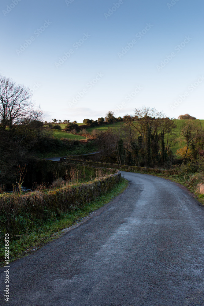 Winding road in Irish countryside with a blue sky