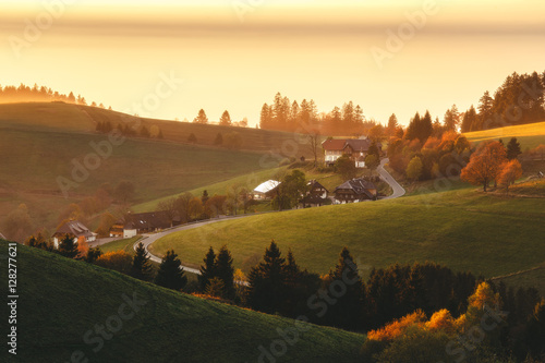 Scenic mountain landscape in autumn at sunset. View over a traditional mountain village in Germany, Black Forest. Colorful dreamy travel background.