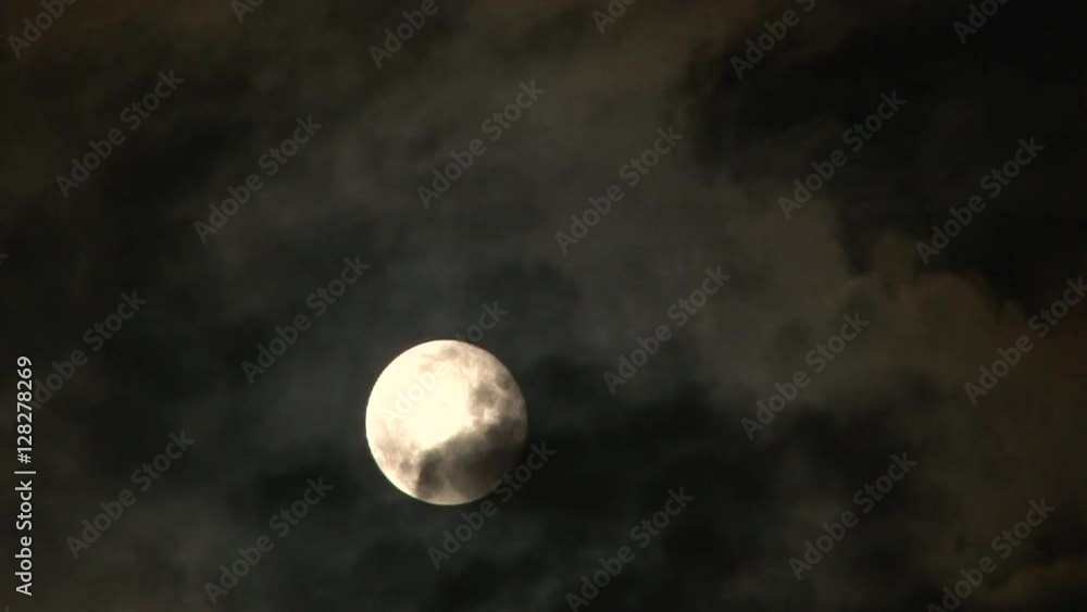 Bright, full super moon rising through cloudscape at night, time lapse. Bright, full super moon rising through cloudscape at night, time lapse.