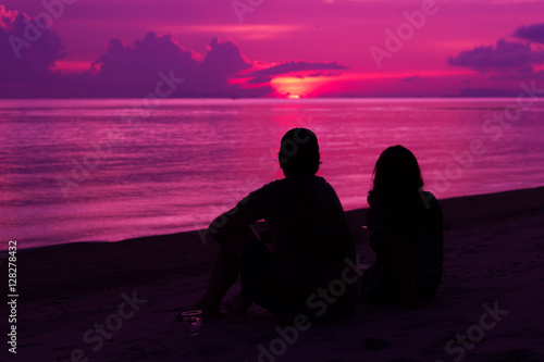 Obraz na płótnie Silhouette of the couple enjoying the sunset on the beach w salonie