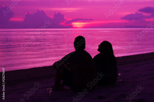 Obraz na płótnie Silhouette of the couple enjoying the sunset on the beach w salonie