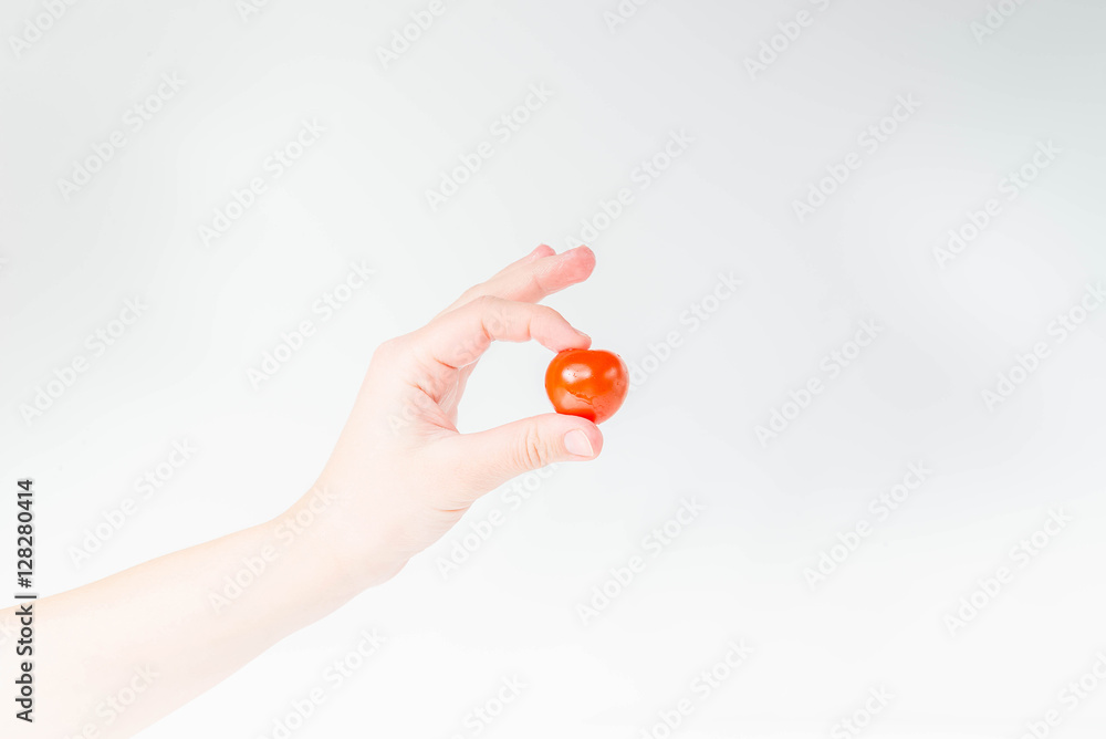 Tomato in woman's hand on a white background Tomato in woman's hand on a white background