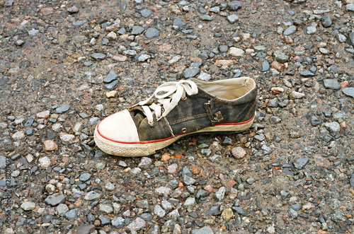 old shoe on stony road, close-up