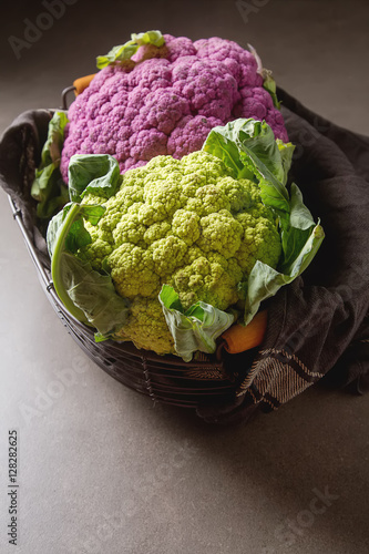 Rainbow of organic cauliflower in a metal basket with a dark clo