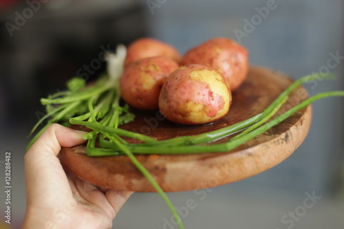 Sliced, peeled raw potatoes with a knife on  board
