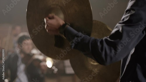 Man playing on ride cymbal on the symphony hall. Shot on RED EPIC Cinema Camera in slow motion. photo