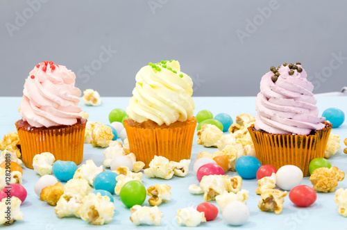 Pink frosted cupcakes on light blue background
