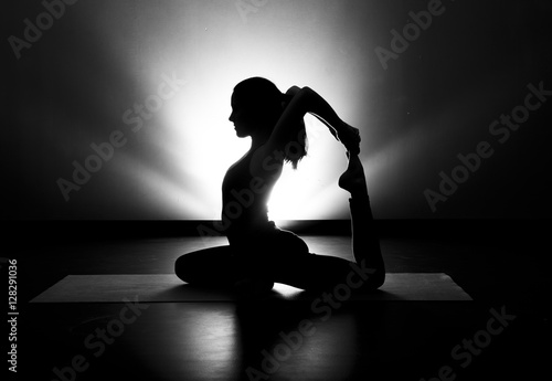 Woman doing yoga pigeon pose silhouette black and white