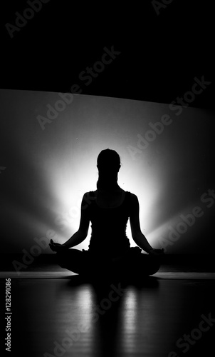 Woman doing yoga meditation silhouette black and white