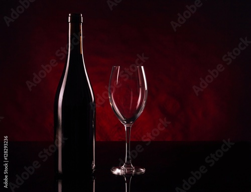 Bottle of red vine and empty vineglass