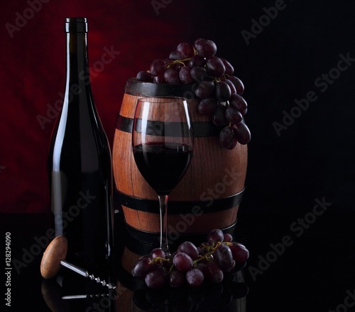 Bottle with red vine. Barrel, bottle and vineglass photo