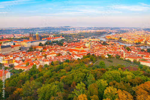Aerial view of Prague cityscape with Prague Castle, red roofs of Lesser Town, Vltava river, and trees on Petrin Hill on sunny day. Capital city of Czech Republic, Europe