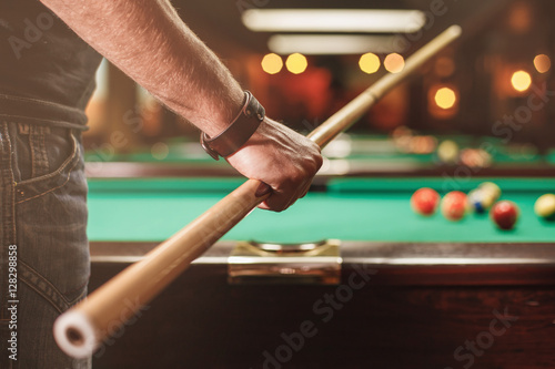 Canvas Print Man with cue opposite to a billiard table.