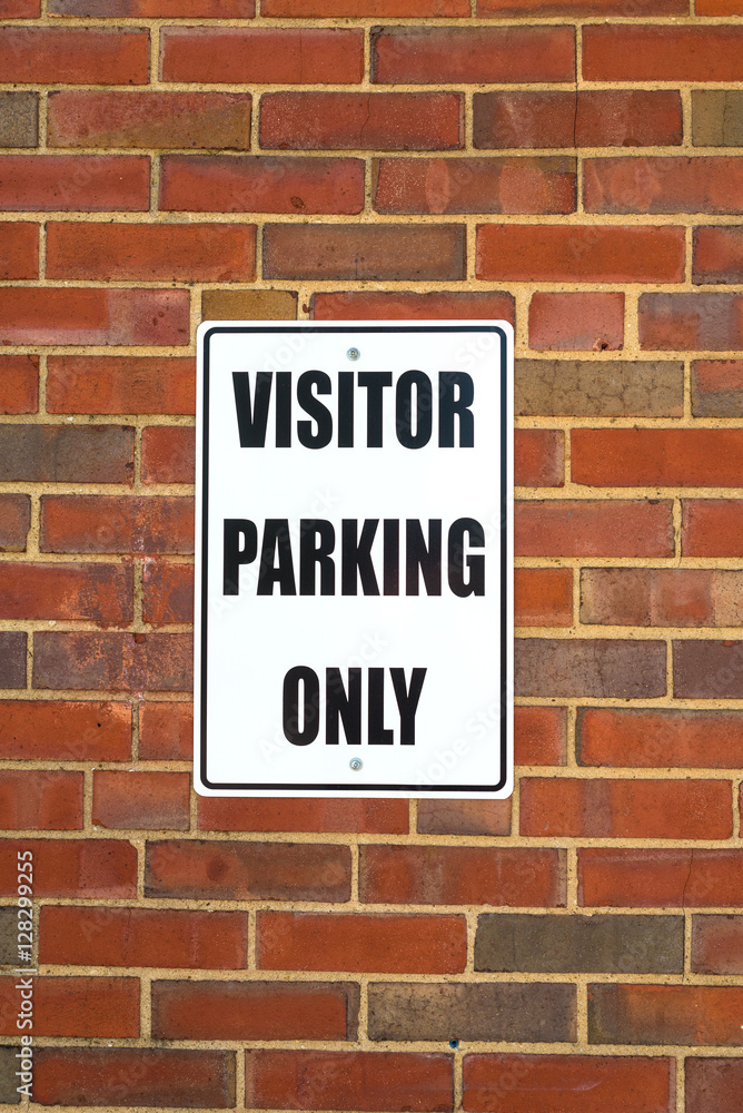 Visitor parking sign on a business wall Visitor parking sign on a business wall