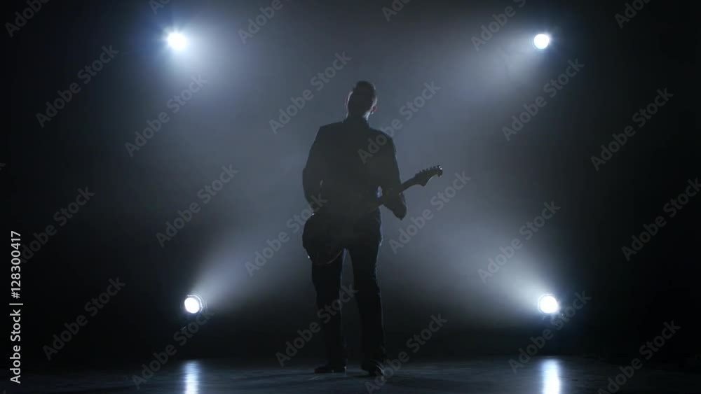 Guitarist in a dark studio plays a fast melody Guitarist in a dark studio plays a fast melody