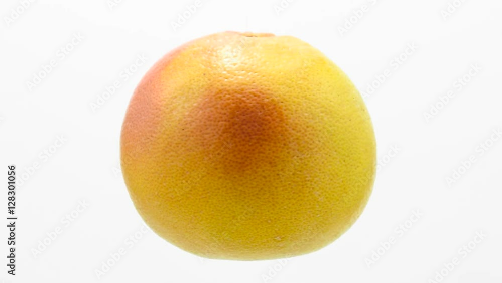Orange grapefruit suspended in the air rotates in loop Orange grapefruit suspended in the air rotates in loop