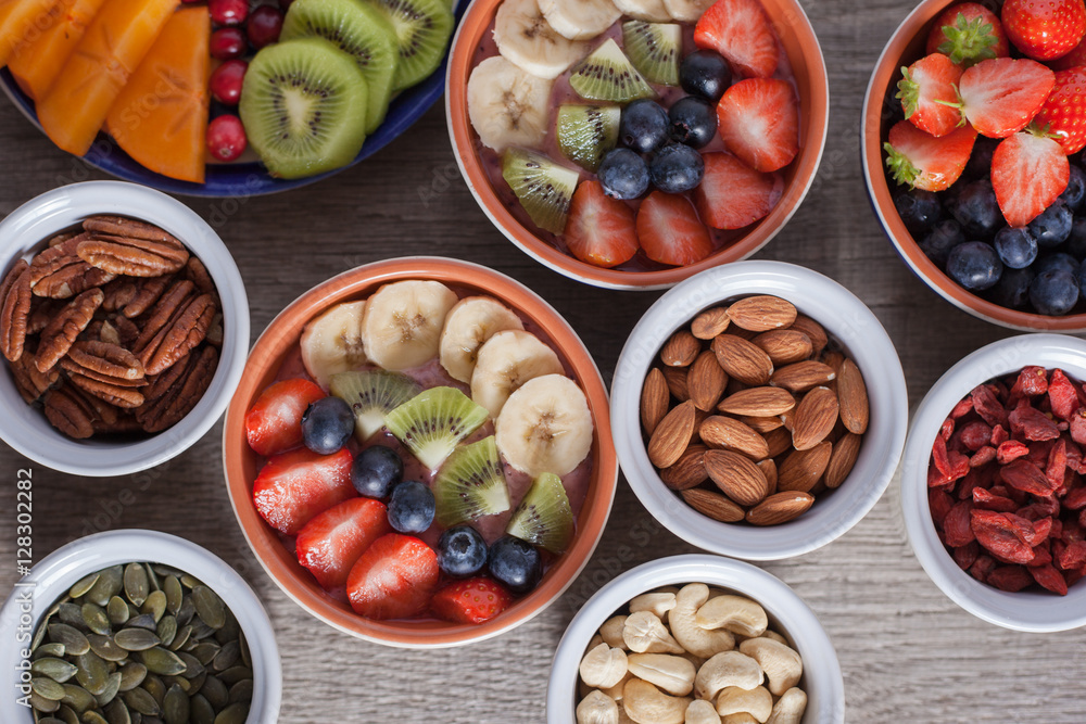 Smoothie with fruits and berries on the grey wooden table, with variety of fruits and nuts around, selective focus, top view Smoothie with fruits and berries on the grey wooden table, with variety of fruits and nuts around, selective focus, top view