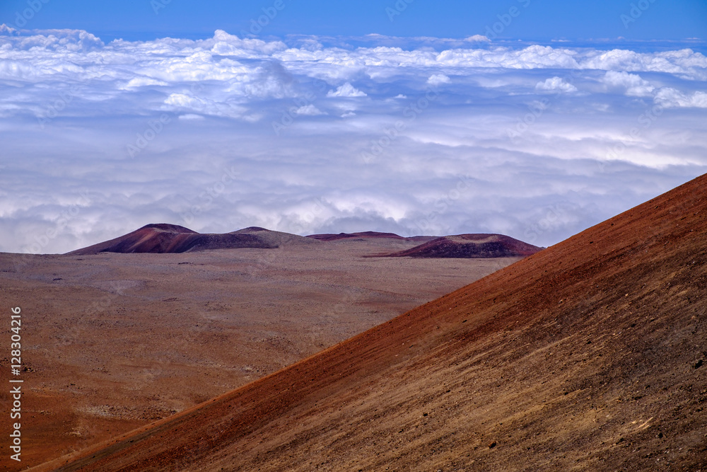 Landscape view of volcanic craters above clouds at Mauna Kea, Hawaii