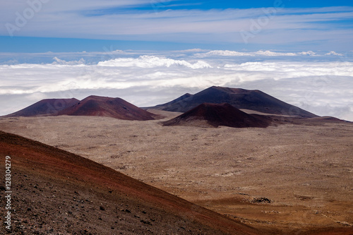 Landscape view of volcanic craters above clouds at Mauna Kea, Hawaii