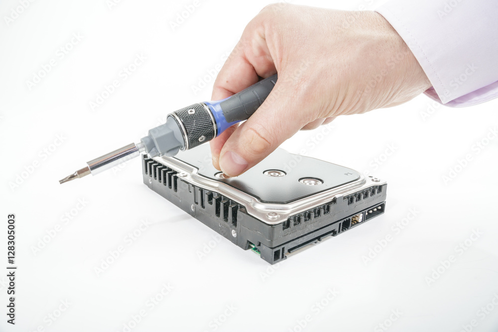 Hand repairman unscrews the 3.5 inch hard drive cover with a screwdriver. Isolated on white background. Hand repairman unscrews the 3.5 inch hard drive cover with a screwdriver. Isolated on white background.