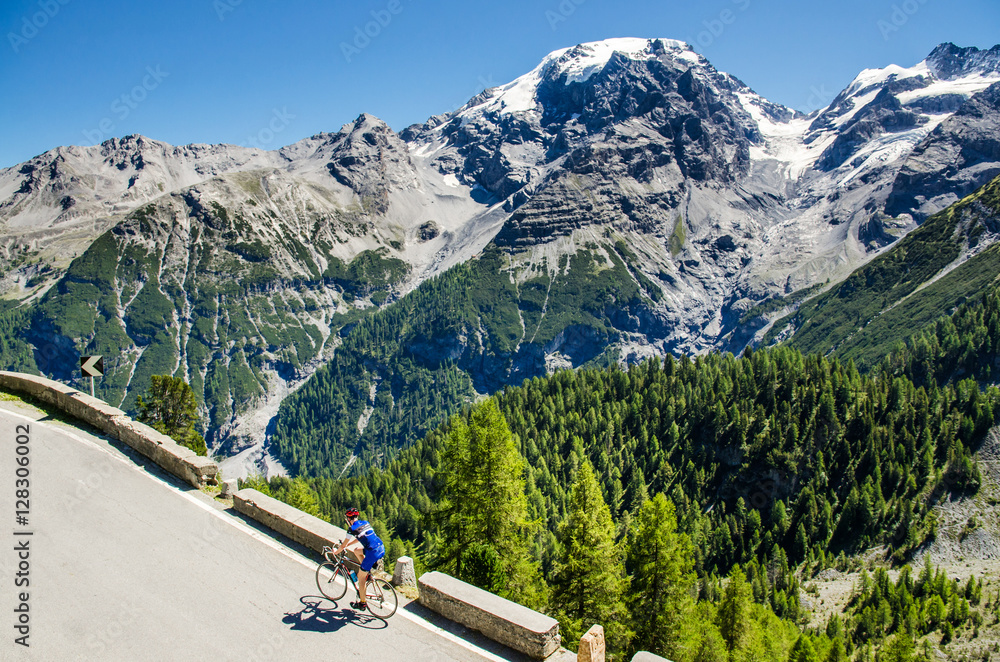 Fototapeta premium Famous Passo Dello Stelvio Road in Swiss - Italy border. Favourite place for all bike riders. Alone biker on the top.