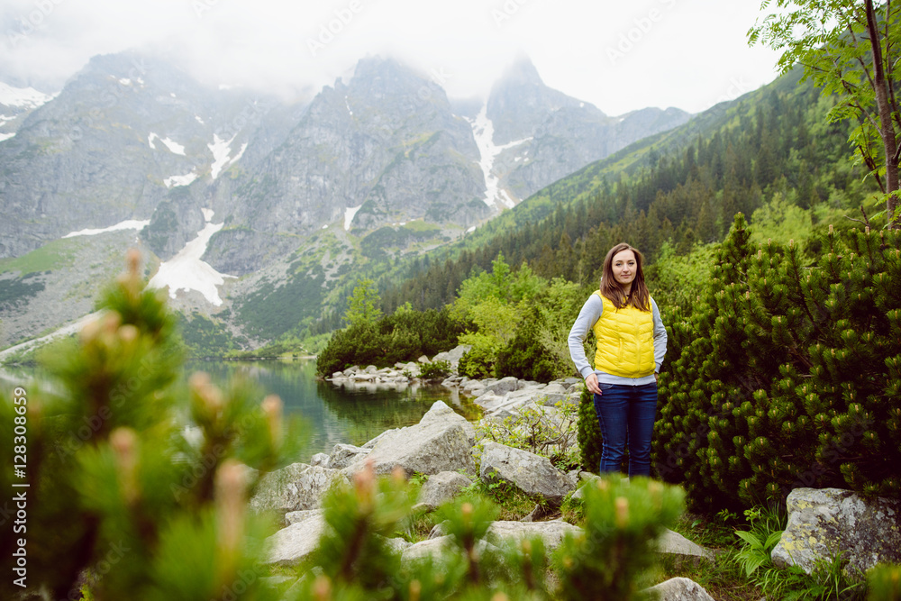 Naklejka premium woman relaxing on the lake and mountains sunny landscape