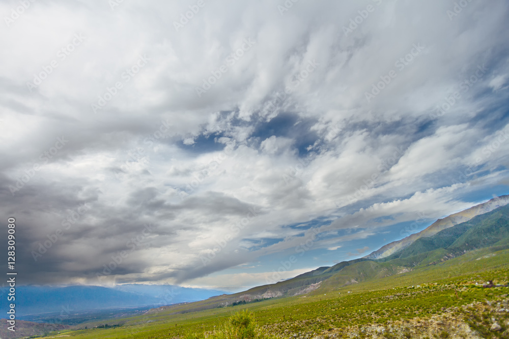 Green meadow with valley, mountains and low clouds near Tafí de Green meadow with valley, mountains and low clouds near Tafí de
