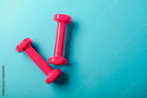 Pair of pink 1 kg dumbbells on blue background