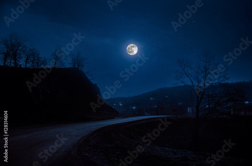 Full moon over road at night photo