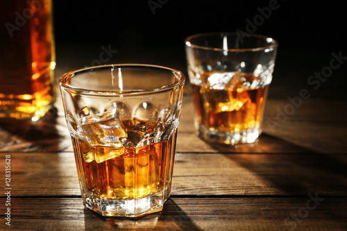 Fotografie, Obraz Glasses of whisky on wooden table closeup
