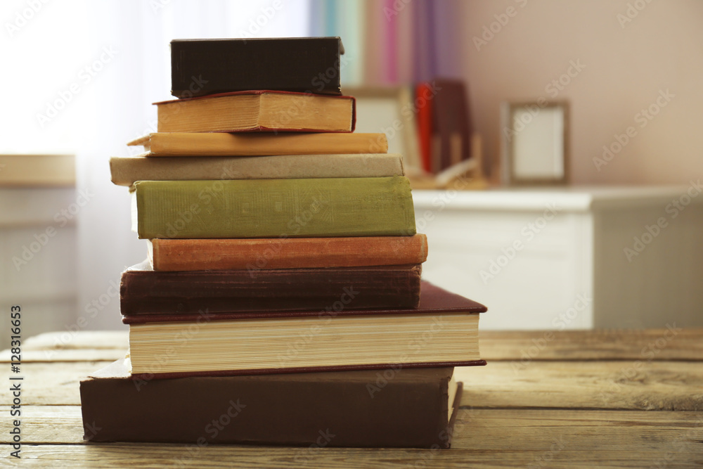 Pile of books on table in the room Pile of books on table in the room
