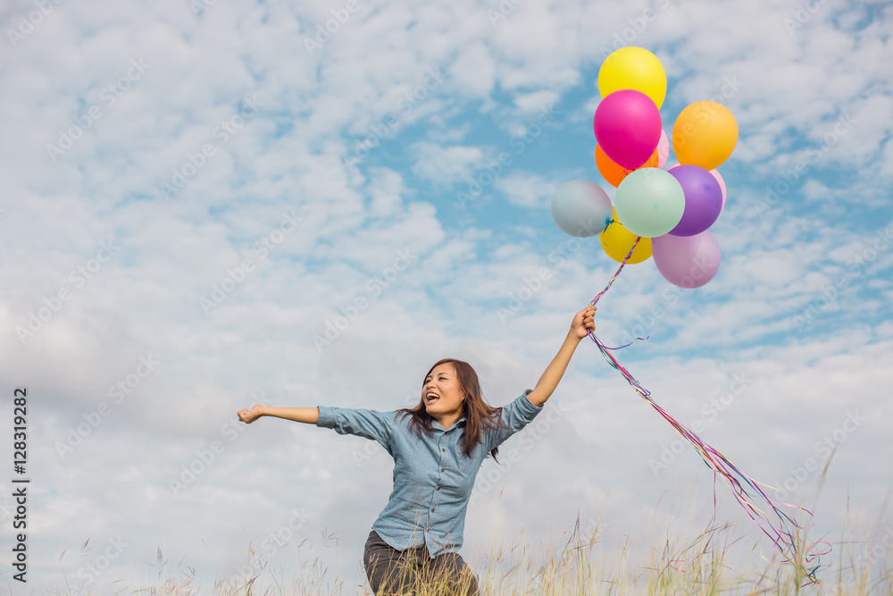 Beautiful Girl jumping with balloons on the beach