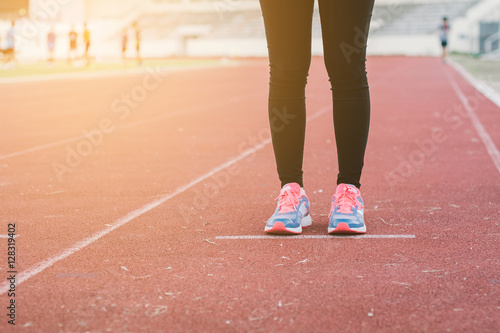 Young lady running on road closeup on shoe., at time sunset