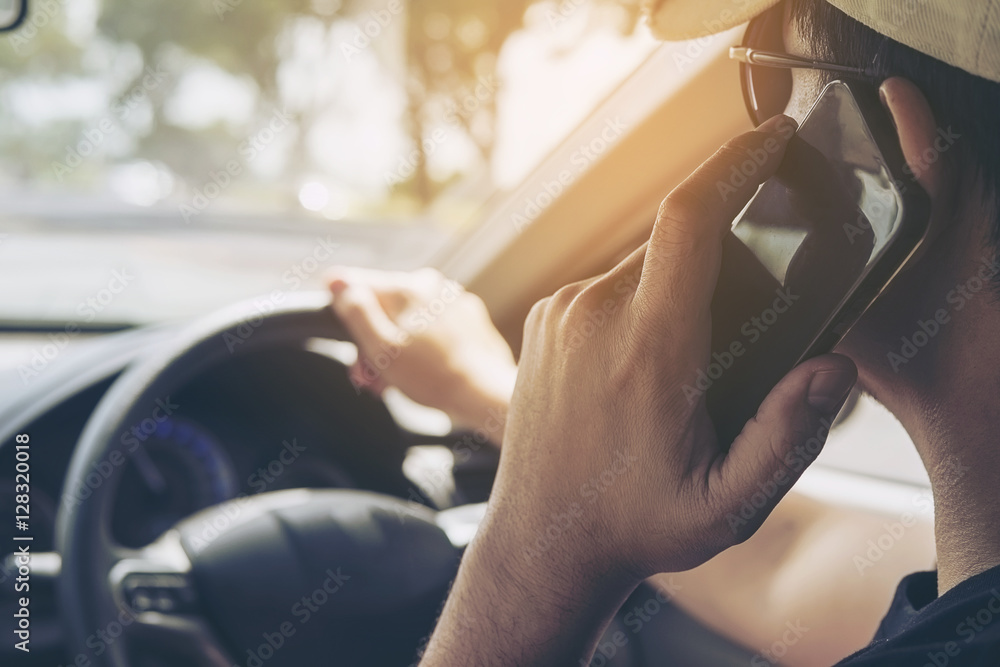 Close up of a man driving car dangerously while using mobile phone Close up of a man driving car dangerously while using mobile phone