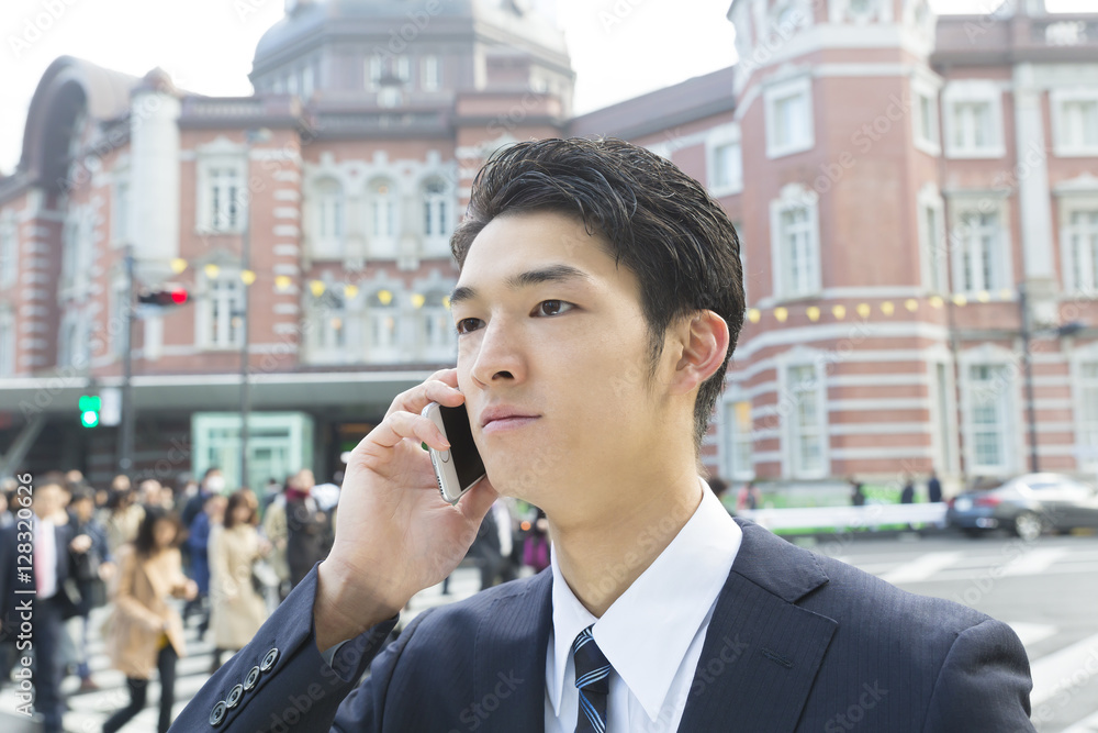 男性 ビジネスマン スマホ 話す 外 東京駅前 朝 通勤客背景 男性 ビジネスマン スマホ 話す 外 東京駅前 朝 通勤客背景