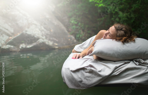Tablou pe pânză A hidden place. Sleeping woman in deep forest lies on airbed