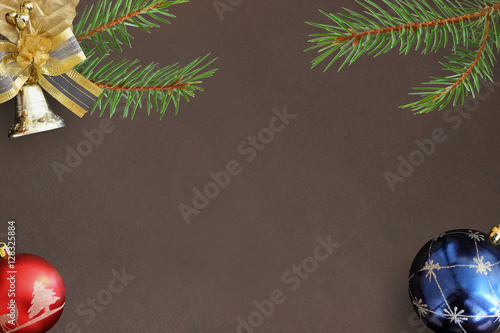 Christmas fir branch, red and blue balls and decorative bell on dark background photo