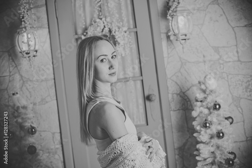 young woman sits amid the Christmas interior