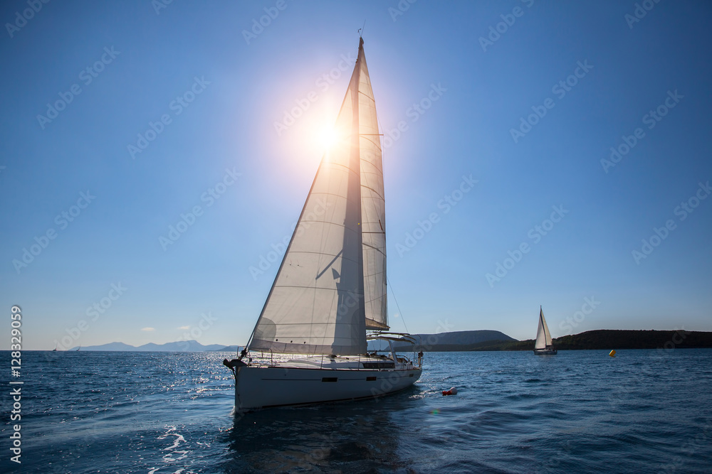 Luxury sailing ship yachts boat with white sails in the Sea.