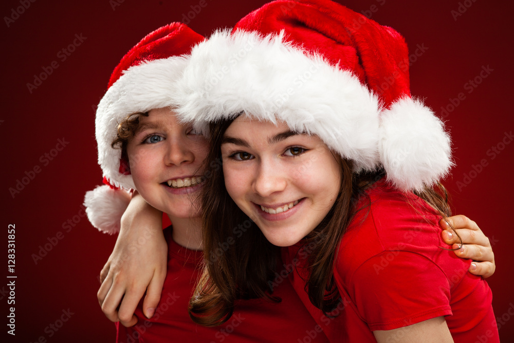 Christmas time - girl and boy with Santa Claus Hat Christmas time - girl and boy with Santa Claus Hat