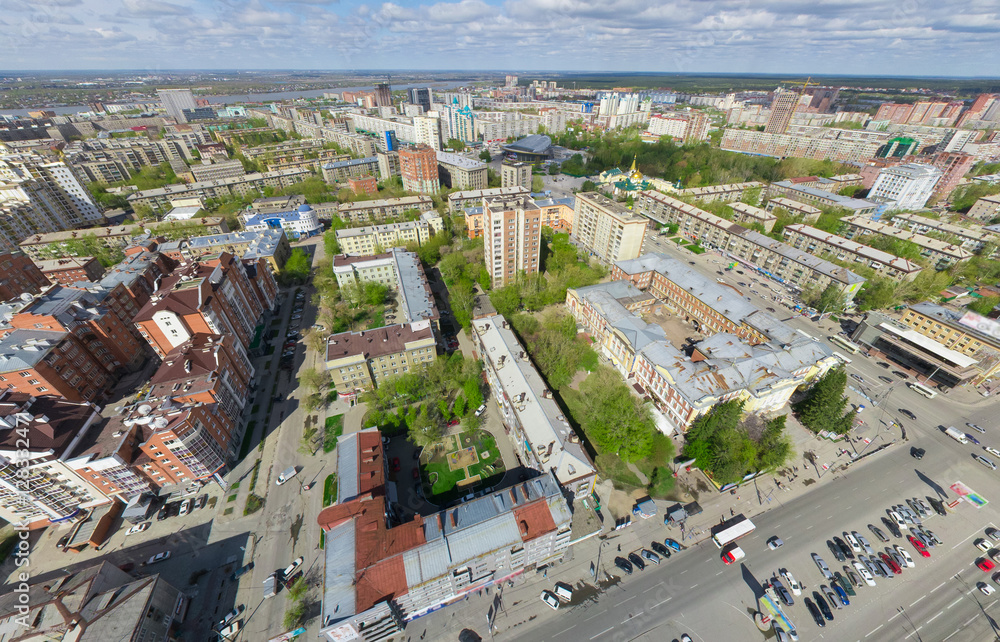 Fototapeta premium Aerial city view with crossroads and roads, houses, buildings, parks and parking lots, bridges. Copter shot. Panoramic image.