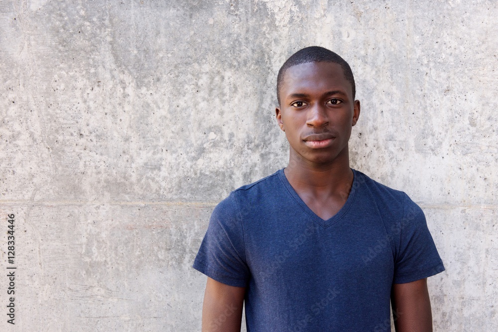 Young african man standing agaisnt gray wall Young african man standing agaisnt gray wall