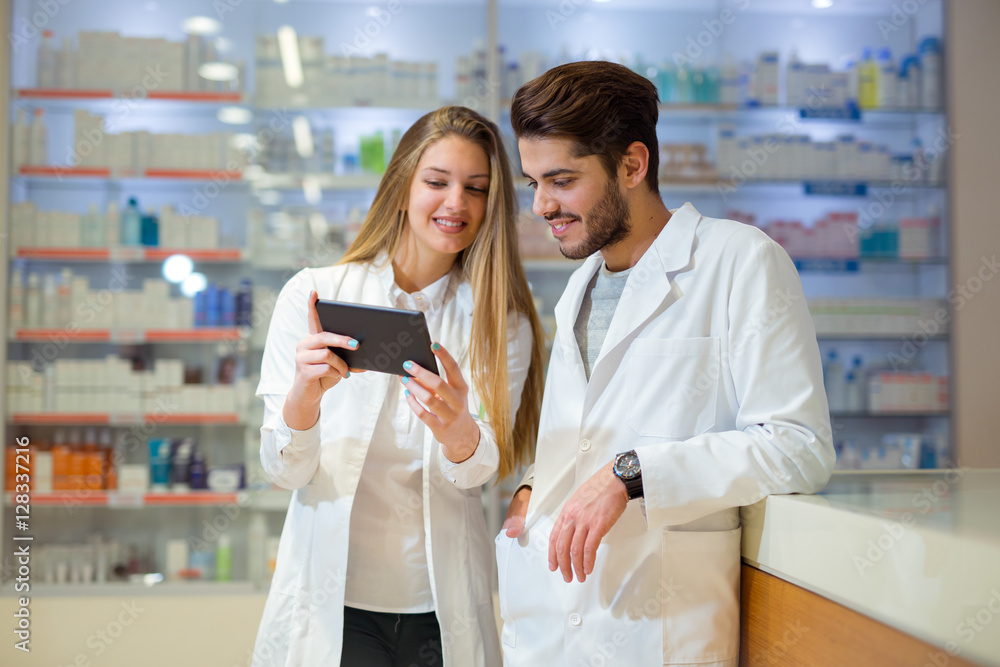Obraz premium Pharmacists using digital tablet while checking medicine in pharmacy